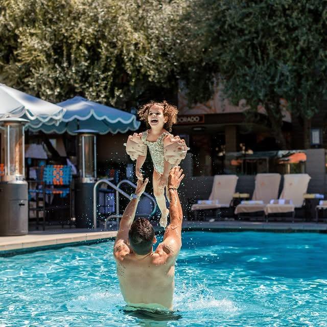 a father and daughter playing in the pool